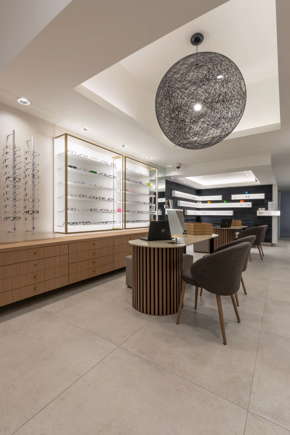 Vue d'ensemble du magasin : suspensions sphériques, présentoirs et coin essayage — Optic Wery