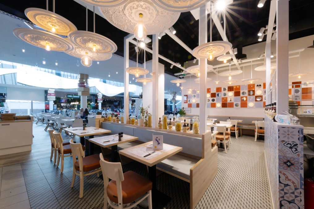 Salle et bar vus depuis l'étage : pergola blanche et luminaires design — La Vita e Bella - Grands Prés