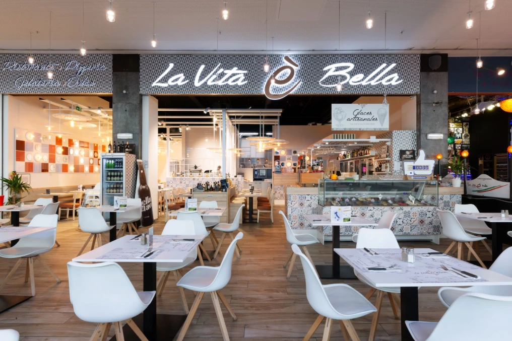 Entrée du restaurant avec enseigne lumineuse et espace repas — La Vita e Bella - Grands Prés
