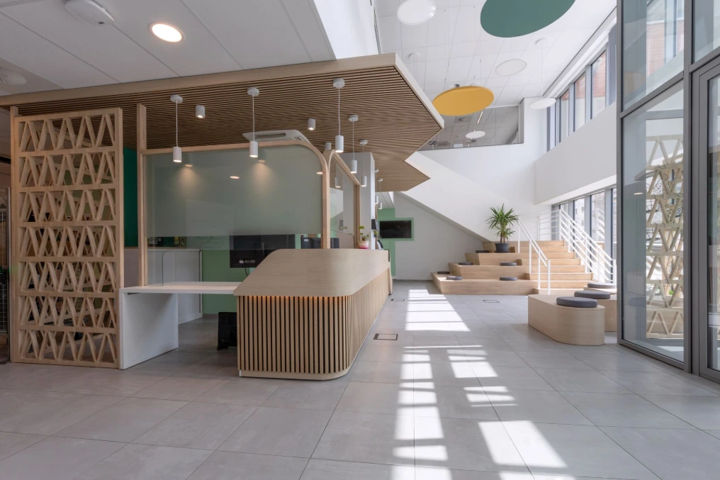Comptoir d'accueil en lattes de bois et claustra à motif triangulaire — Service Public de Wallonie