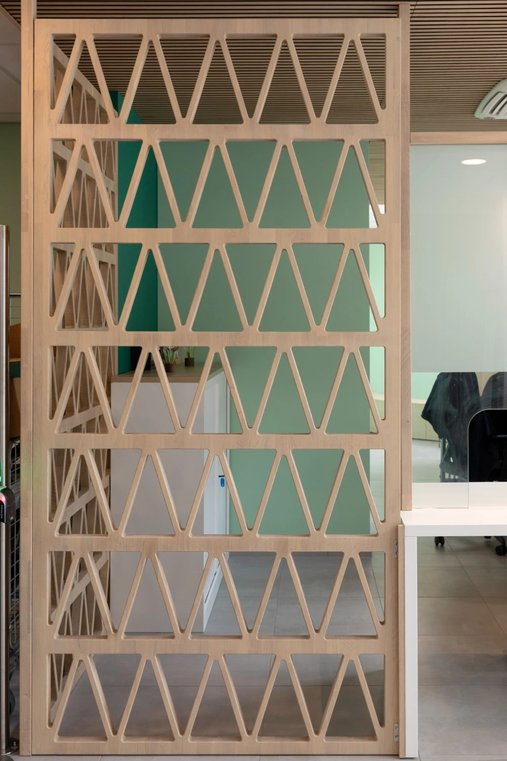 Claustra en bois à motif triangulaire séparant l'accueil des bureaux — Service Public de Wallonie