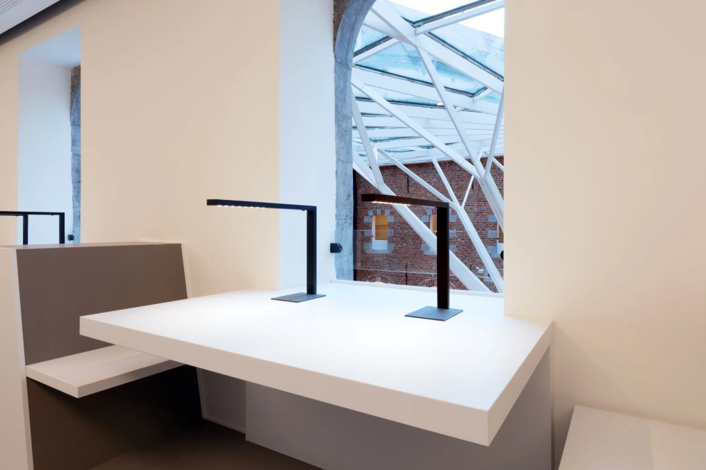 Tablette de travail blanche avec lampes sous la verrière — Bibliothèque U-Mons