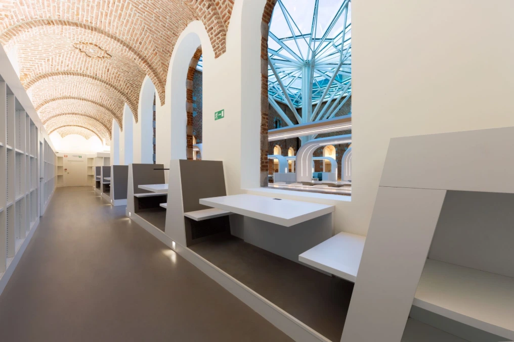 Enfilade des postes de lecture le long des arcades — Bibliothèque U-Mons
