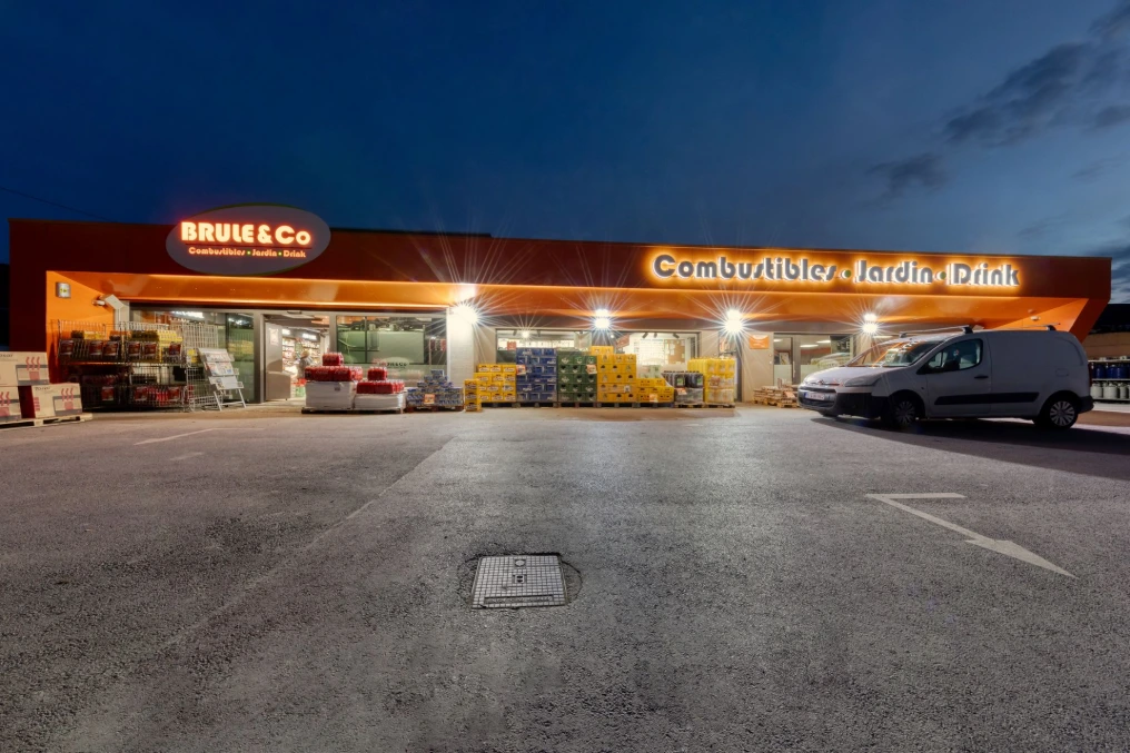 Façade et parking du magasin éclairés de nuit — Brule & Co