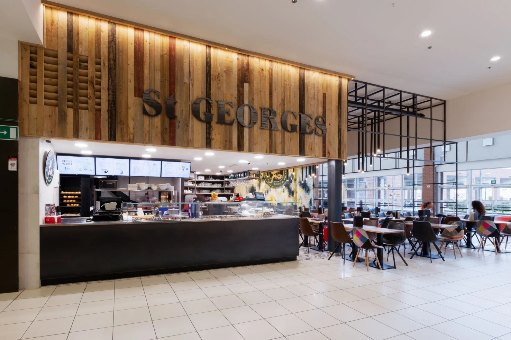 Comptoir en bois et métal noir sous l'enseigne murale — St Georges