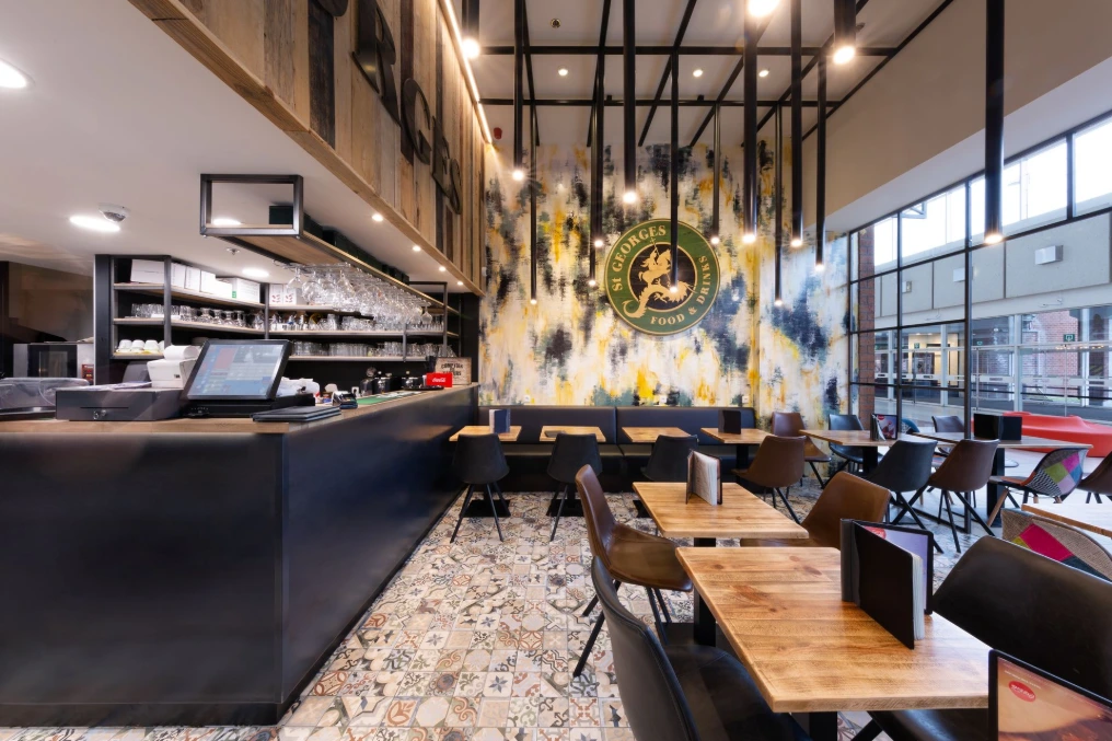 Banquettes et tables hautes le long de la fresque murale — St Georges