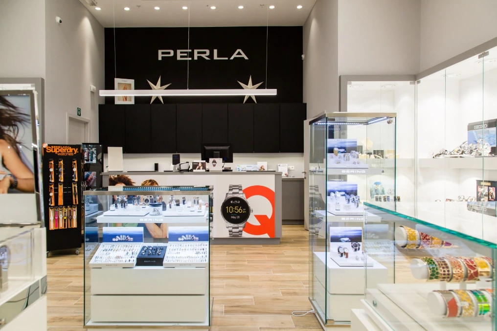 Intérieur : comptoirs vitrines et enseigne rétroéclairée — Perla Docks