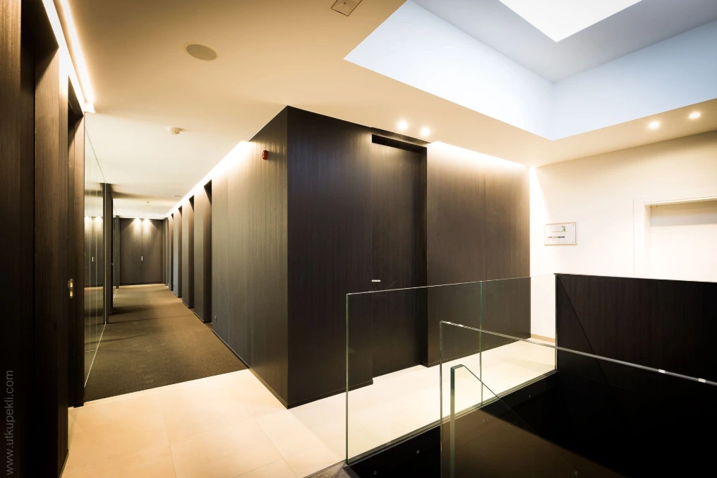 Couloir de bureaux avec cloisons vitrées et menuiseries sombres — Lexar Technics