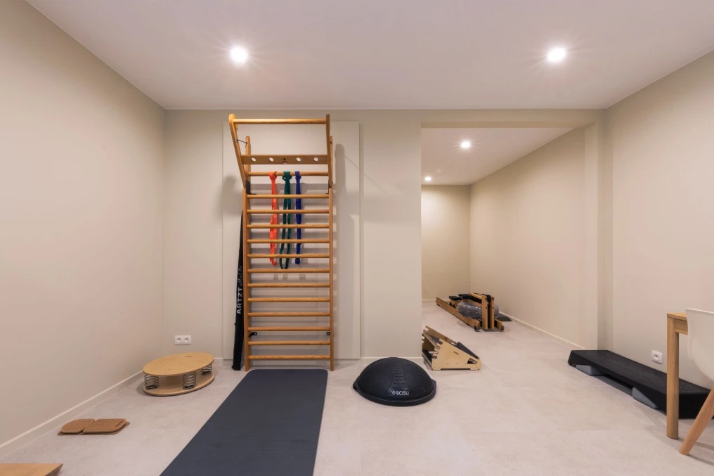 Salle d'exercice avec espalier mural, tapis et matériel de rééducation — Mykine Demoulin