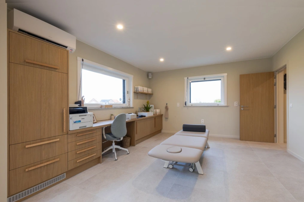 Cabinet de soins : table de massage, bureau et rangements en bois clair — Mykine Demoulin