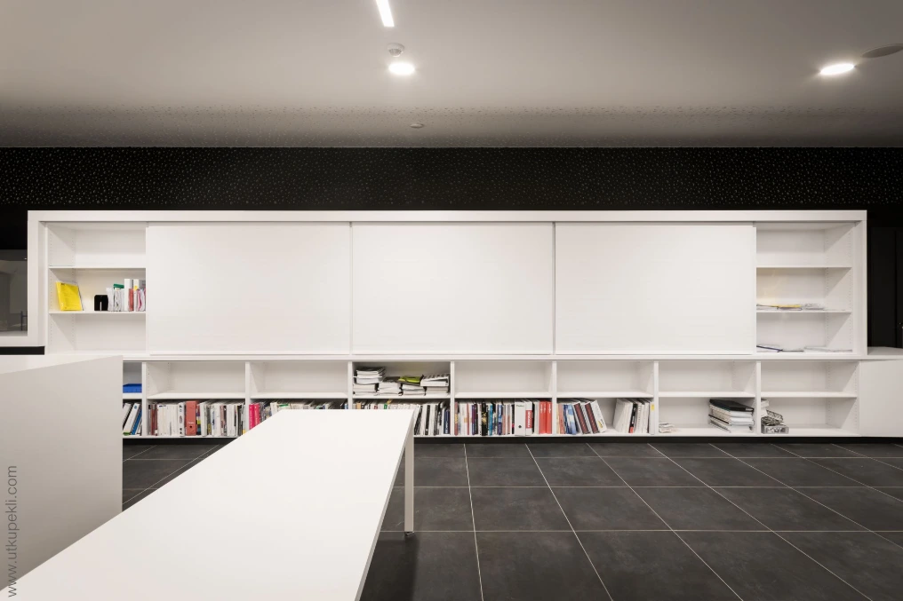 Espace de travail avec plan blanc, bibliothèque et sol sombre — Eurecayphas