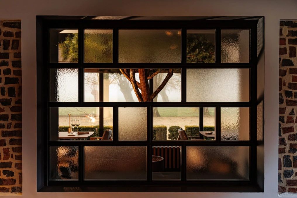 Verrière atelier en métal noir sur mur en pierre — Le Bouchon et l'Assiette