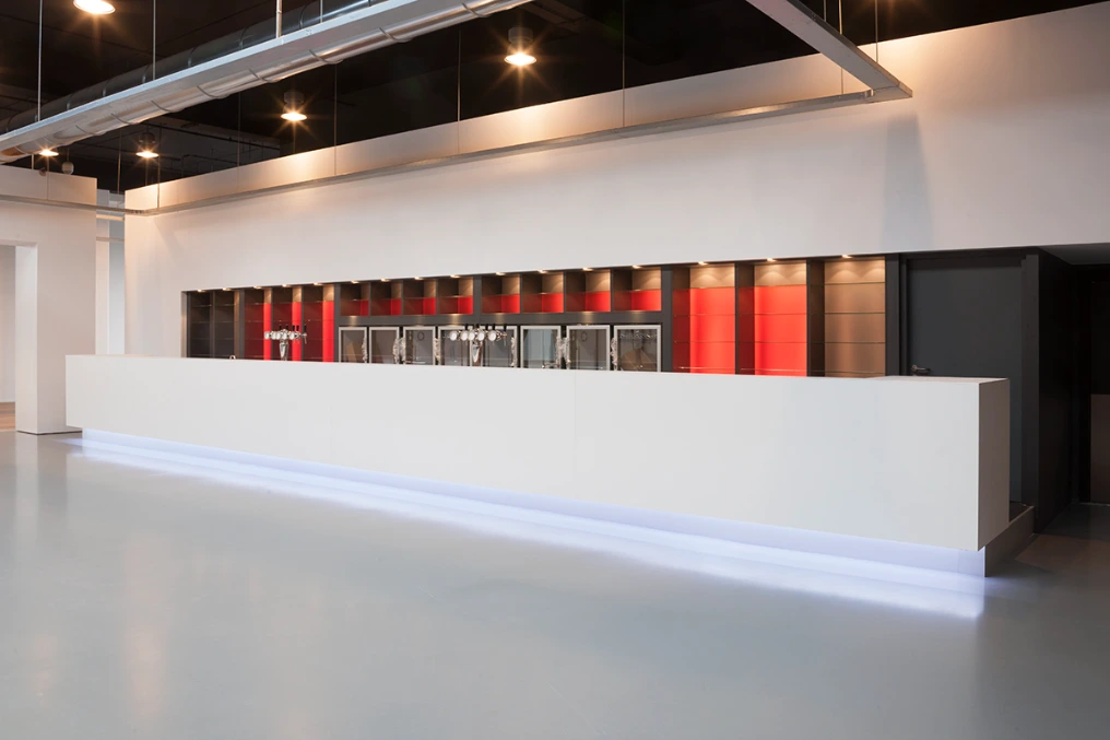 Bar du hall vu d'ensemble : comptoir blanc et niches rouges — Louvexpo - La Louvière