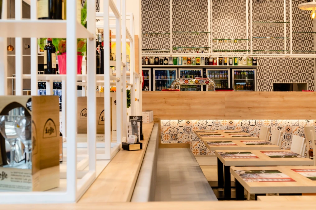 Espace repas avec claustra blanc et banquettes le long du mur — La Vita e Bella - Bastions
