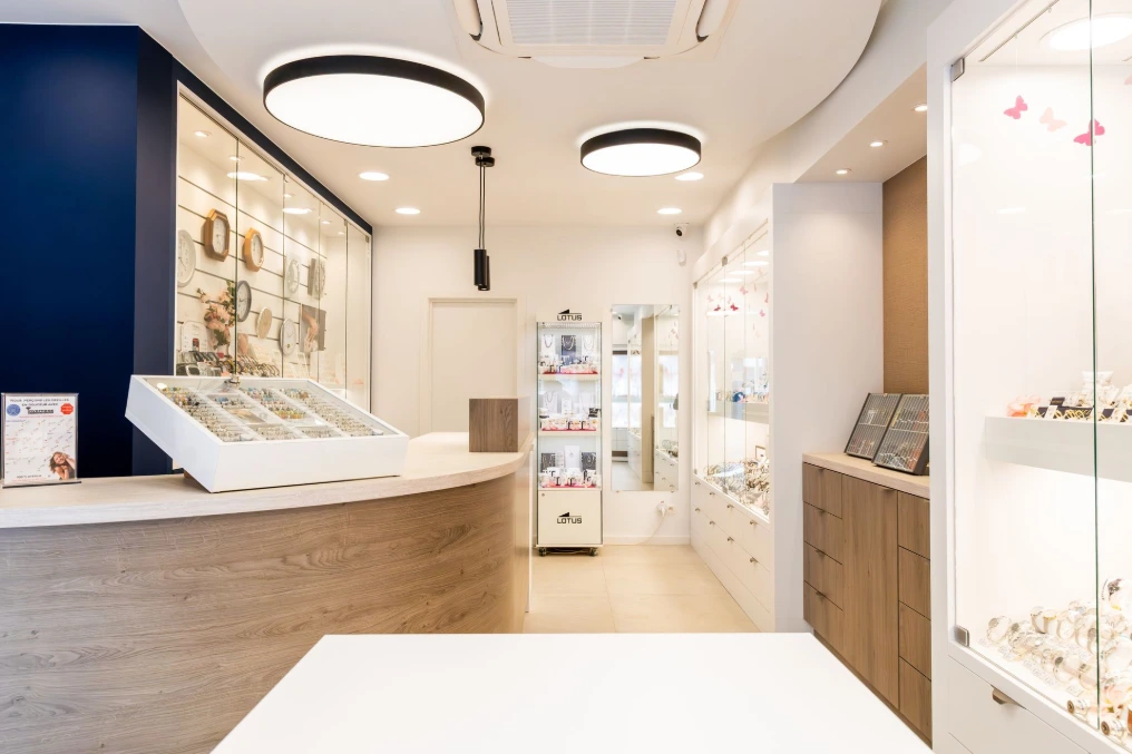 Comptoir vitrine en bois clair devant un mur bleu nuit — Bijouterie Bayet