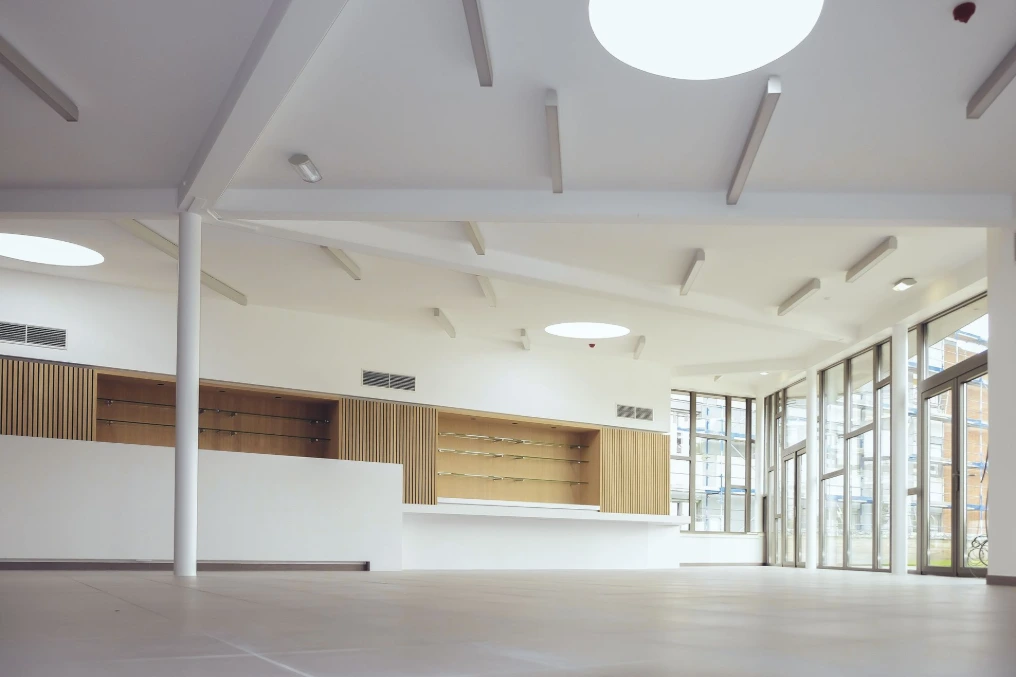 Salle commune avec comptoir en longueur et habillage bois, avant emménagement — Maison de repos Les Buissonnets