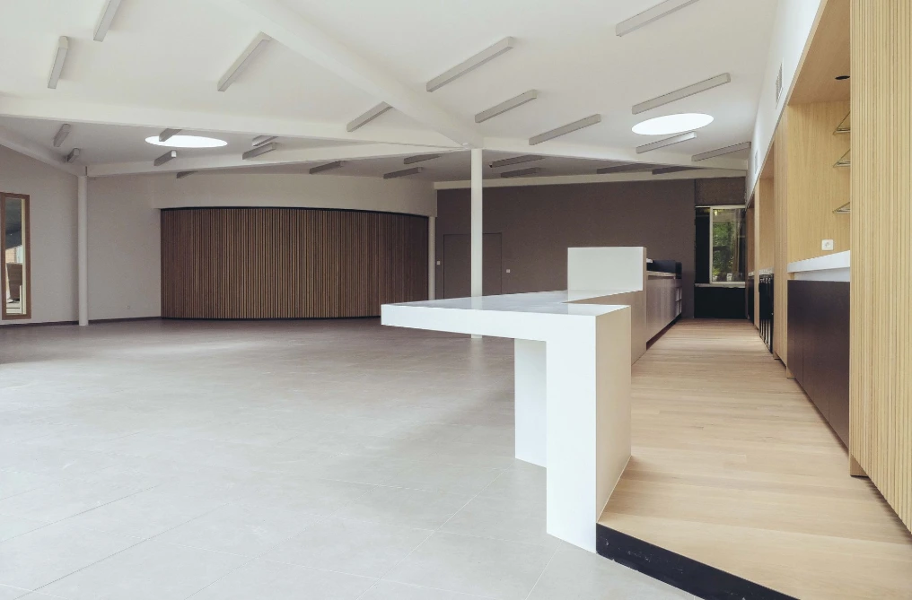 Salle commune vue vers le bar, charpente apparente — Maison de repos Les Buissonnets