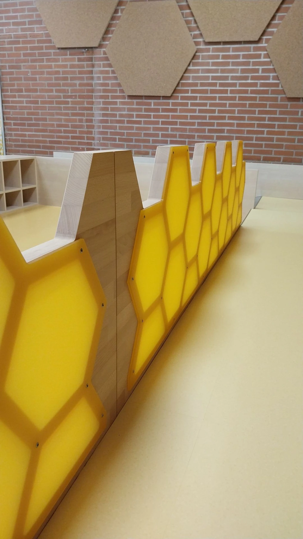 Détail du garde-corps en panneaux jaunes découpés en nids d'abeilles — École maternelle Morlanwelz