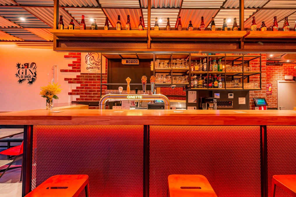 Salle du café : banquettes rouges, tables et bar au fond — Café « Le Parapluie National »
