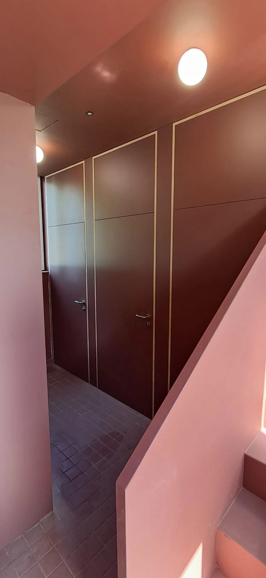 Escalier avec habillage de panneaux et mur rose — Bibliothèque Rebecq