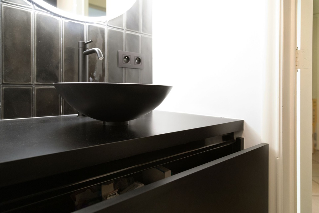 Vasque à poser sur meuble suspendu noir et carrelage gris — Modifications d'une cuisine et rénovation d'une salle-de-douche