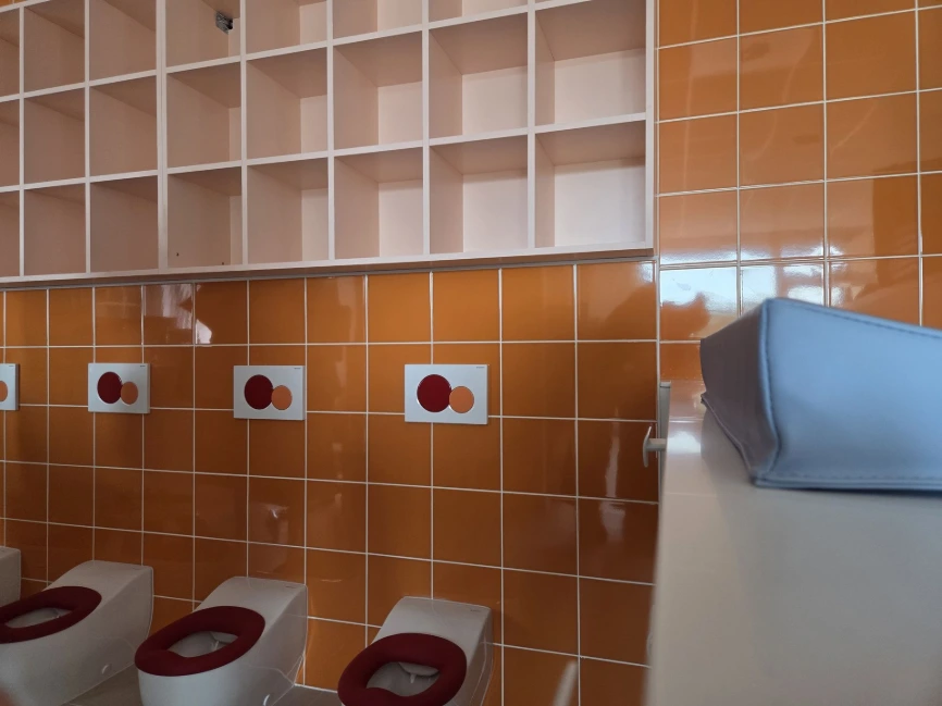 Bloc sanitaire enfants : petits WC et carrelage orange — Crèche « Les bulles d'O »