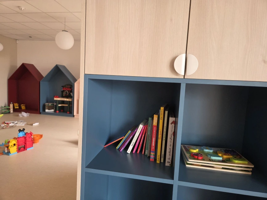 Casier-bibliothèque bleu et maisonnettes murales de la salle de jeux — Crèche « Les bulles d'O »