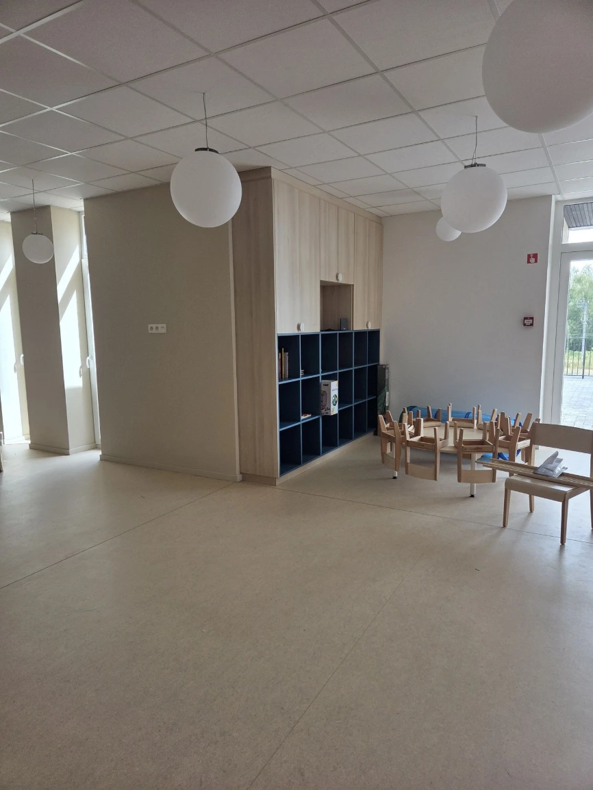 Salle de vie avant aménagement, avec meubles bas et petites tables — Crèche « Les bulles d'O »
